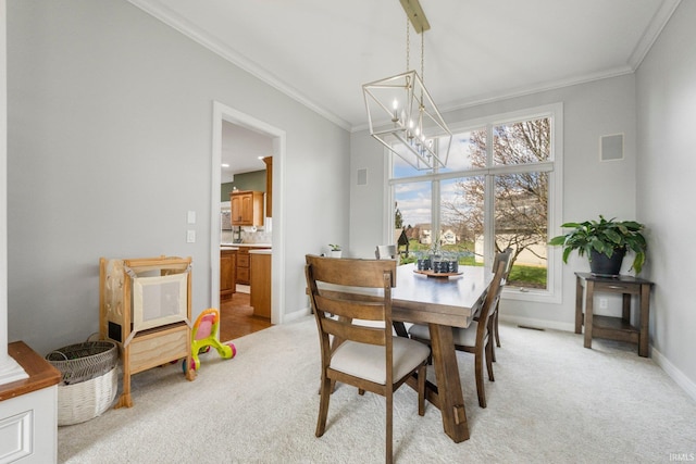dining area featuring visible vents, baseboards, ornamental molding, a chandelier, and light colored carpet