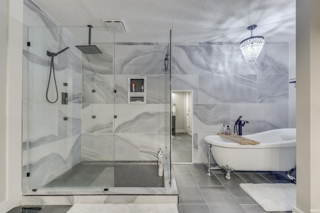 8780 N Old State Road 37th Rd, Bloomington, IN 47408 - full bathroom with a freestanding bath, a notable chandelier, tile walls, a textured ceiling, and a marble finish shower