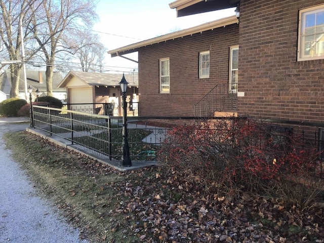213 S Monticello St, Winamac, IN 46996 - view of side of home featuring a detached garage, fence, and brick siding