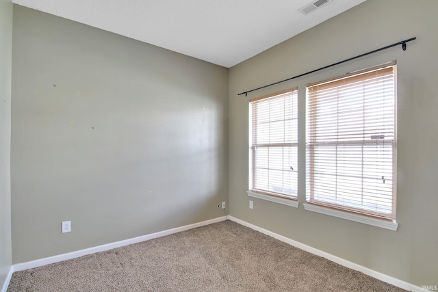 carpeted empty room featuring visible vents and baseboards