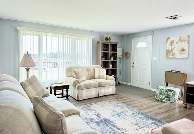 342 E Himes St, North Webster, IN 46555 - living area featuring a decorative wall, a wealth of natural light, wood finished floors, and baseboards