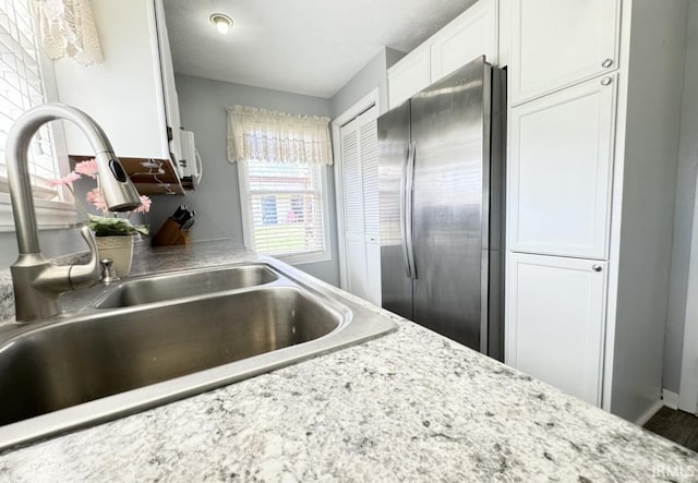 342 E Himes St, North Webster, IN 46555 - kitchen featuring white cabinets, a sink, and freestanding refrigerator
