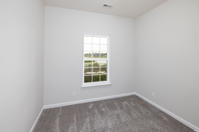 spare room featuring baseboards, visible vents, and carpet floors