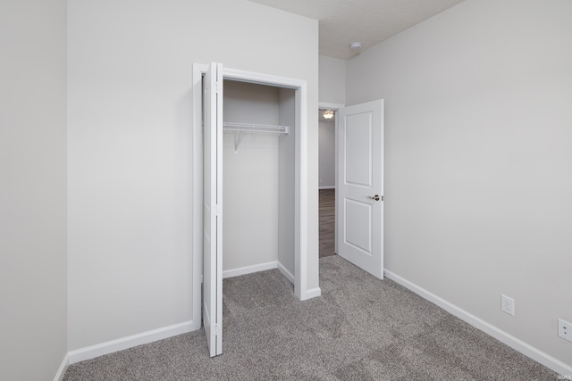 unfurnished bedroom featuring a closet, carpet flooring, and baseboards