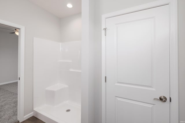 full bathroom with a shower stall, baseboards, and a ceiling fan