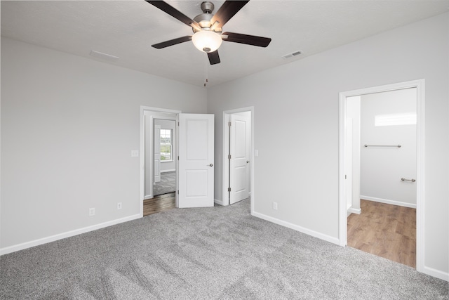 unfurnished bedroom with carpet flooring, visible vents, baseboards, and a ceiling fan