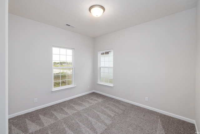 carpeted spare room with baseboards and visible vents