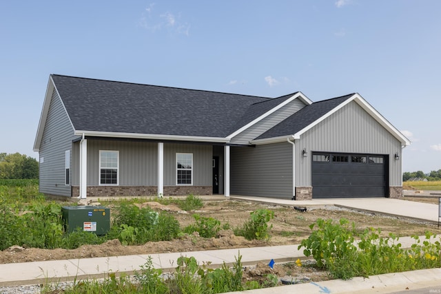 view of front facade featuring brick siding, a shingled roof, driveway, and an attached garage