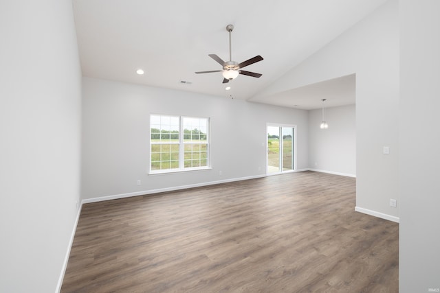 empty room with dark wood finished floors, baseboards, a ceiling fan, and vaulted ceiling