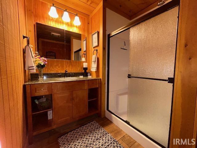 3008 Chigger Ridge Rd Unit 395, 396, Birdseye, IN 47513 - full bathroom with wood finished floors, vanity, wood walls, and a stall shower