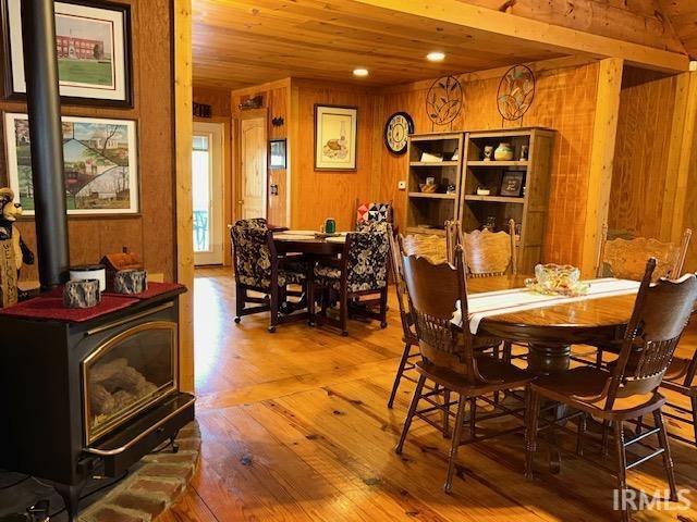3008 Chigger Ridge Rd Unit 395, 396, Birdseye, IN 47513 - dining space with hardwood / wood-style flooring, a wood stove, wood walls, and wooden ceiling