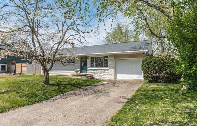 ranch-style home featuring a front yard, an attached garage, stone siding, fence, and concrete driveway
