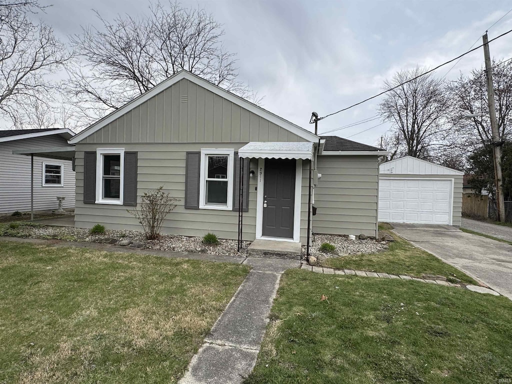 bungalow-style house with driveway, an outdoor structure, a front lawn, and a detached garage