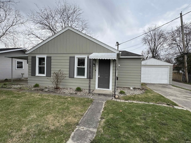 bungalow-style house with driveway, an outdoor structure, a front lawn, and a detached garage