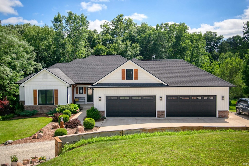 view of front of property with a garage, driveway, stone siding, and a front lawn