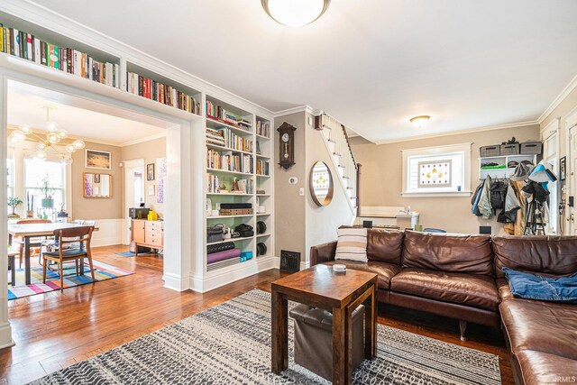 1069 Riverside Dr, South Bend, IN 46616 - living area with built in shelves, a notable chandelier, crown molding, stairway, and wood finished floors