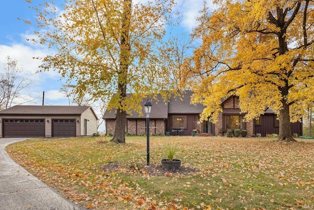 view of front of home with an outbuilding, a detached garage, and a front yard