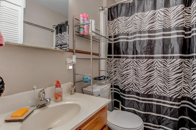 bathroom with a shower with shower curtain, vanity, and toilet