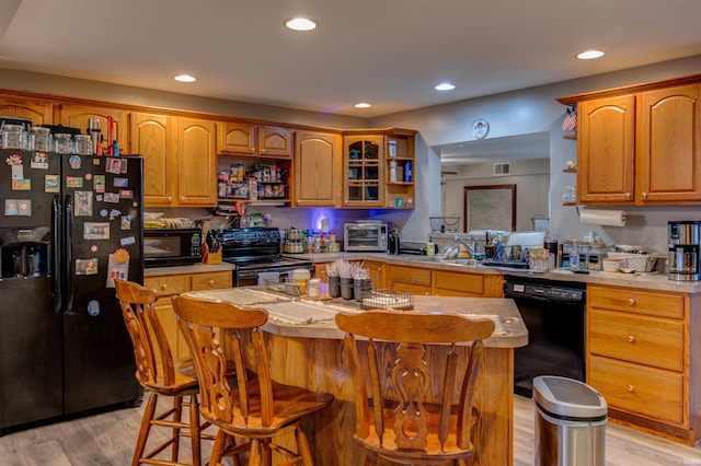 kitchen with open shelves, a sink, black appliances, recessed lighting, and light wood finished floors