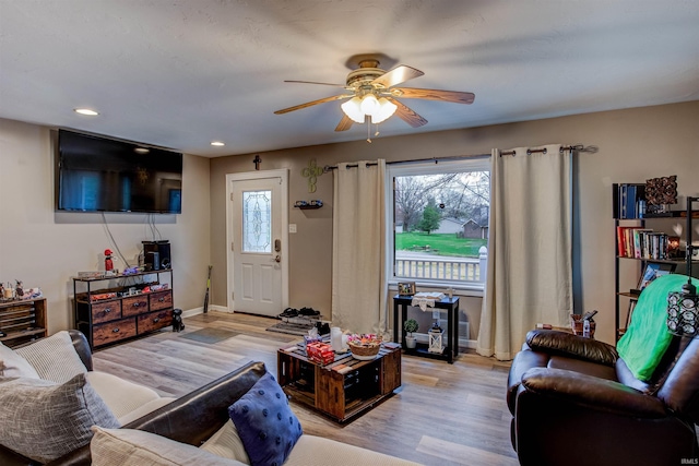 living room with light wood-type flooring, baseboards, a ceiling fan, and recessed lighting