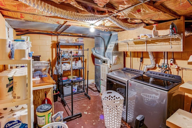 interior space with heating unit, washing machine and dryer, laundry area, and concrete block wall