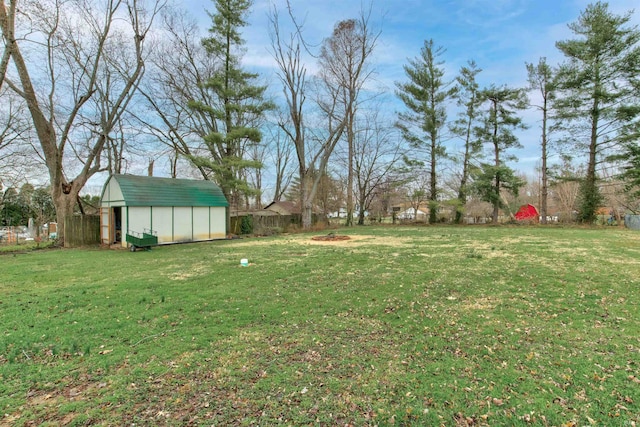 view of yard with a storage shed, fence, and an outdoor structure