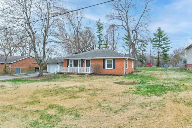 ranch-style home with a garage, roof with shingles, a front yard, brick siding, and concrete driveway