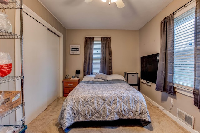 bedroom featuring visible vents, light colored carpet, and multiple windows
