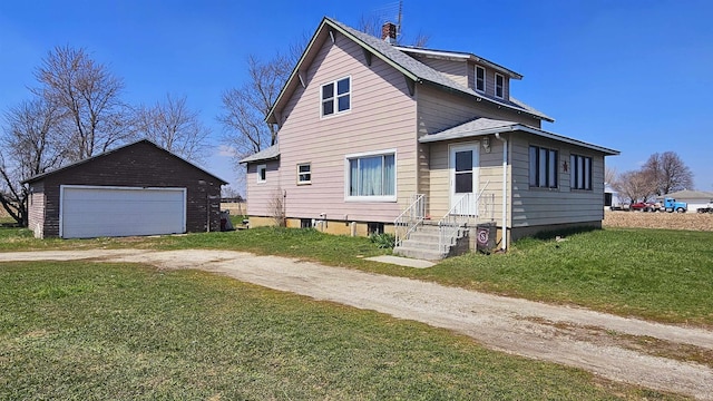 view of front facade featuring a front yard, an outdoor structure, a garage, and a chimney