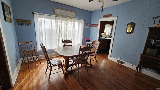 dining space with wood-type flooring, baseboards, a ceiling fan, and visible vents