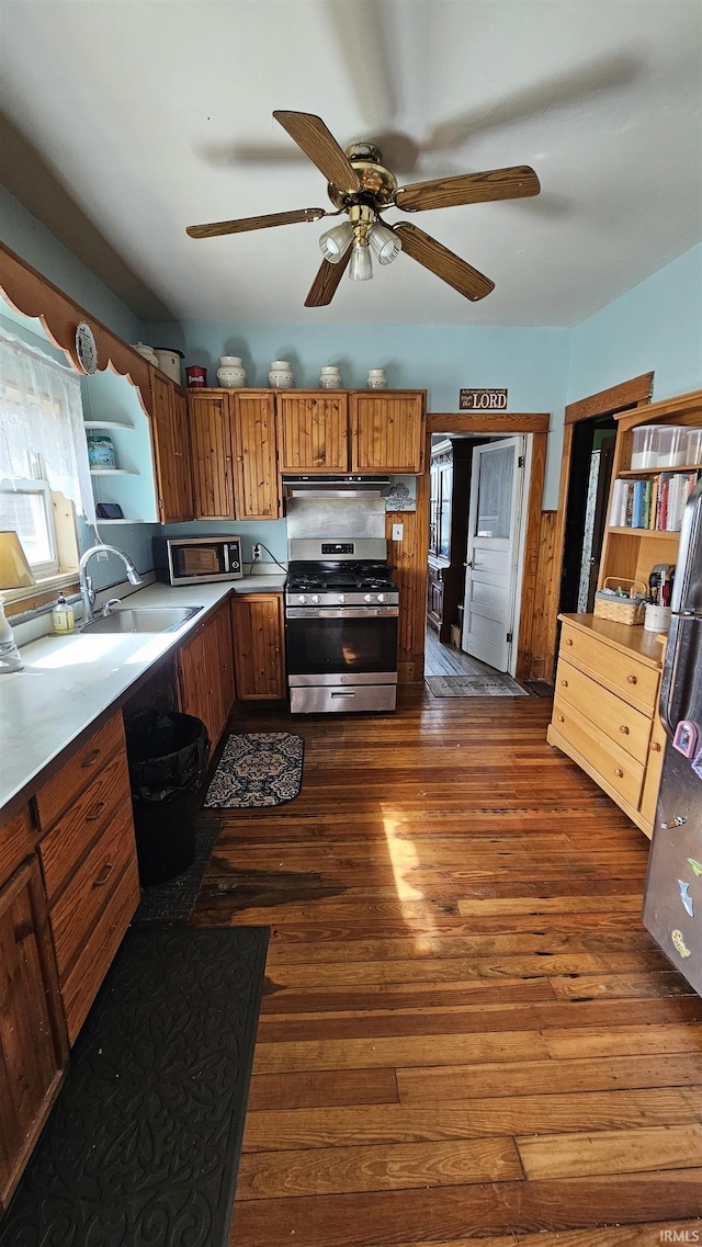 kitchen featuring stainless steel appliances, plenty of natural light, a sink, and brown cabinetry