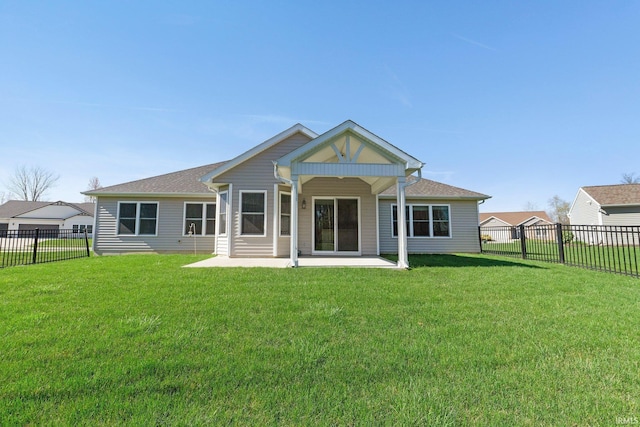 rear view of house with a lawn, a fenced backyard, and a patio