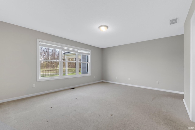 carpeted empty room with visible vents and baseboards