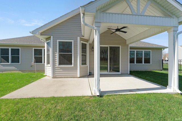 rear view of property with a patio area, a lawn, a ceiling fan, fence, and roof with shingles