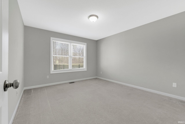 unfurnished room featuring light colored carpet, baseboards, and visible vents
