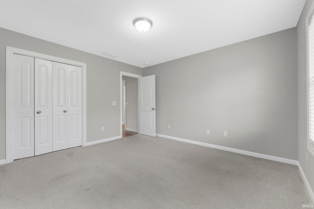 unfurnished bedroom with baseboards, a closet, and carpet
