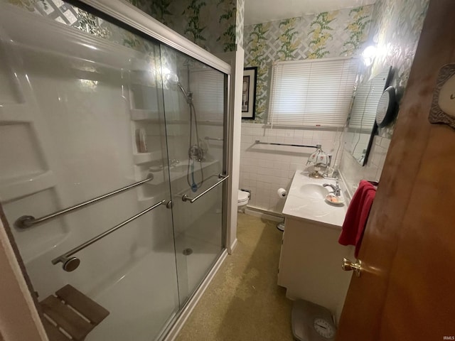 full bath with toilet, a stall shower, wallpapered walls, and vanity