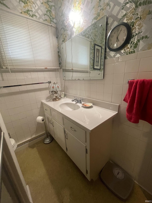 bathroom with vanity, tile walls, and wallpapered walls
