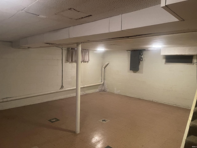 finished below grade area featuring tile patterned floors and electric panel