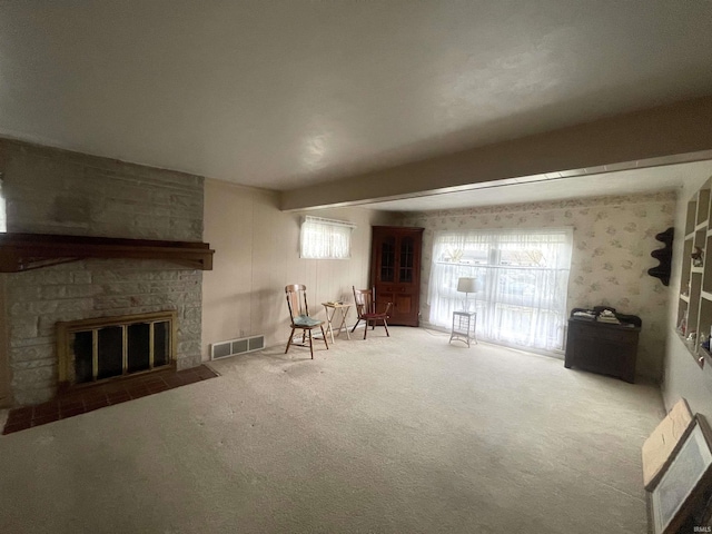 sitting room with visible vents, heating unit, carpet, and a fireplace