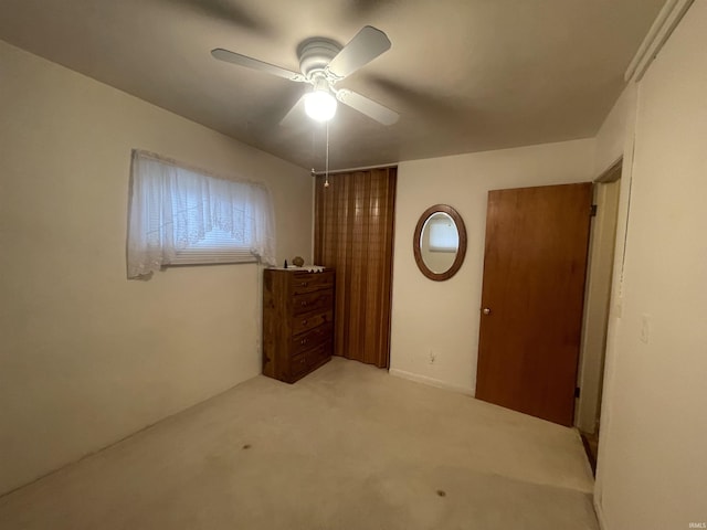 unfurnished bedroom with light colored carpet and a ceiling fan