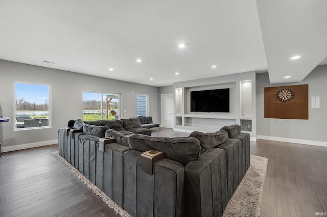 living room with recessed lighting, baseboards, and wood finished floors