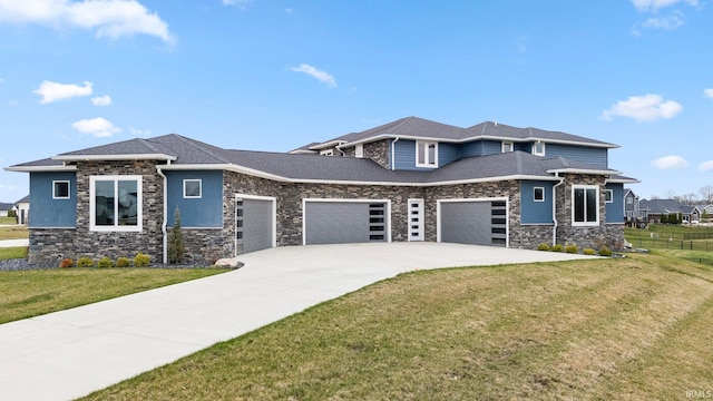 prairie-style home with driveway, stone siding, a front lawn, a garage, and fence