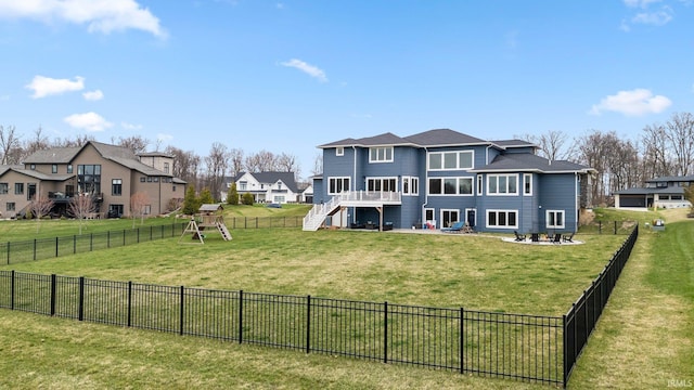 back of property with a patio area, a lawn, a fenced backyard, stairway, and a residential view