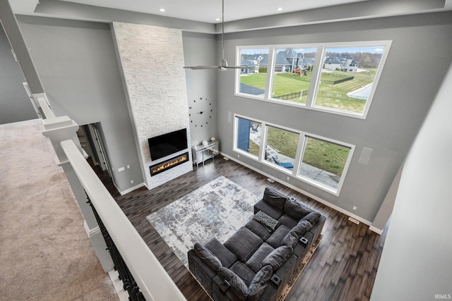 living area with recessed lighting, a fireplace, baseboards, and wood finished floors