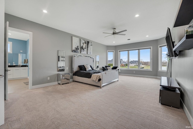 bedroom with ceiling fan, ensuite bathroom, recessed lighting, light carpet, and baseboards
