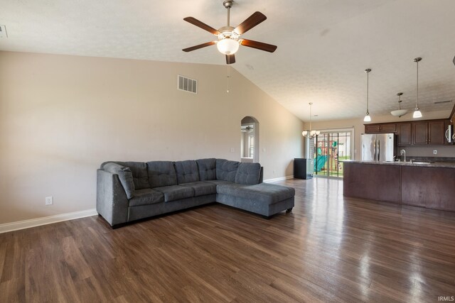 living room featuring arched walkways, a ceiling fan, visible vents, dark wood-style flooring, and baseboards