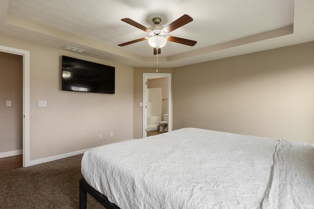 carpeted bedroom featuring a raised ceiling, baseboards, a ceiling fan, and visible vents