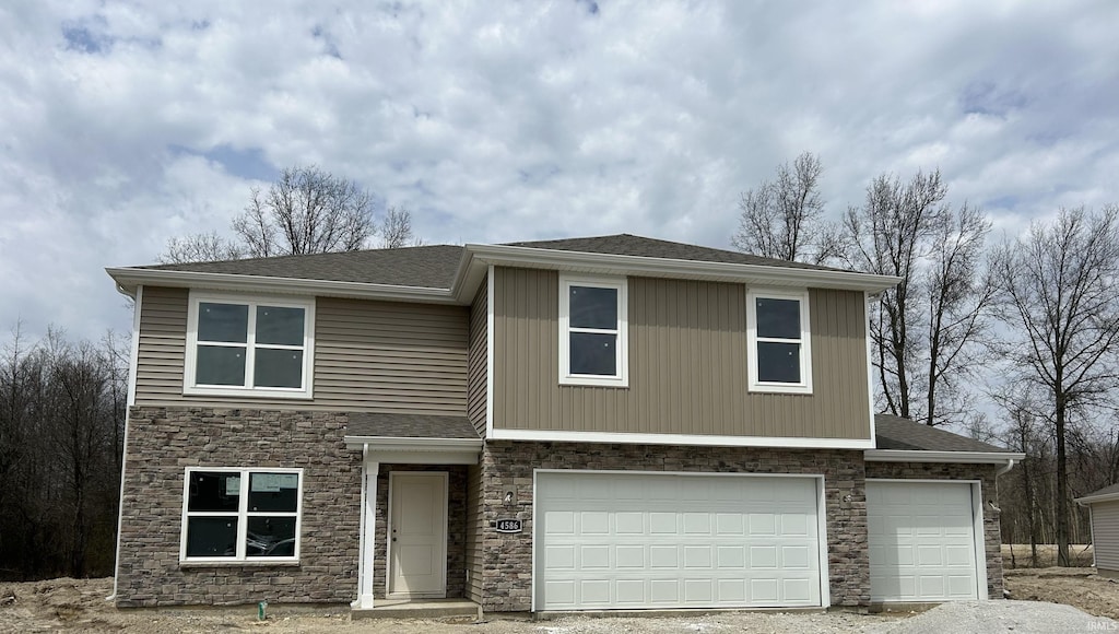 view of front of property featuring a shingled roof, driveway, stone siding, and an attached garage