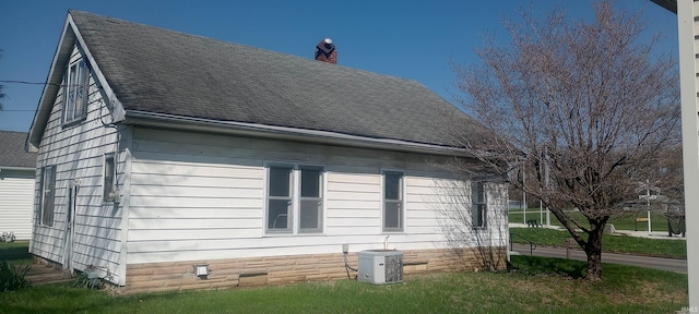 view of property exterior with a chimney, a shingled roof, and central AC unit